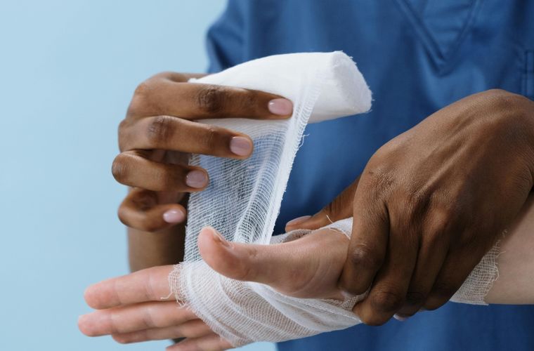 Clinician wrapping an injured hand
